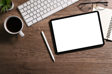 Modern workplace, digital tablet, stylus pen, coffee cup and notebook on wooden table. Top view, Flat lay