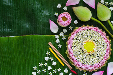 Pink lotus petal krathong decorates with its pollen, crown flower, incense stick and candle for...