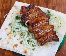 Shish kebab on ribs with onions on pita bread