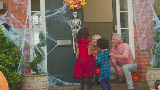 Grandchildren dressed for Halloween visiting grandparents house for trick or treat - shot in slow motion