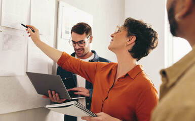 Mature businesswoman discussing some reports with her team