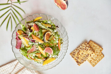 Mediterranean Italian fresh salad with arugula, grain rustic cheese, batata and figs. Healthy appetizer, vegan salad with whole grain cookies