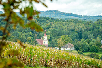 Kościół w górach jesienią, pola i lasy w górach