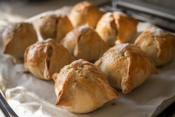 Making apples baked in dough. Yummy hot pastry items with white sugar on top