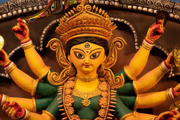 Idol of Goddess Devi Durga at a decorated puja pandal in Kolkata, West Bengal, India. Durga Puja is a famous and major religious festival of Hinduism that is celebrated throughout the world. - obrazy, fototapety, plakaty