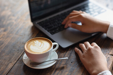 latte coffee cup Asian woman working with laptop in a cafe