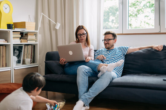 Family Of Three Relaxing At Home