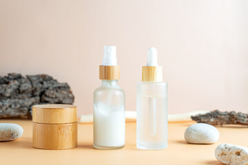Cosmetic skin care products with tree bark and stones on pastel beige background. Mockup fro design