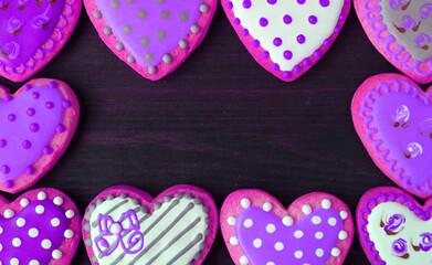 Stunning frames of purple pink heart shaped with adorable pattern cookies on black background