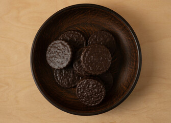 Chocolate chip cookies on a plate on a wooden table.