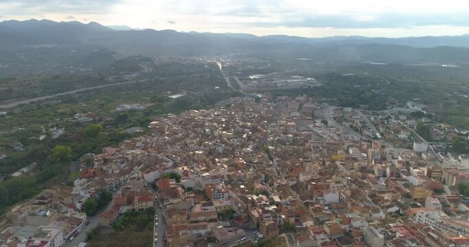 Vuelo de dron sobre pueblo espa&ntilde;ol rodeado de nubes y monta&ntilde;as