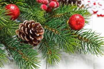 Christmas composition, Christmas tree branch with toys, cones on a wooden background