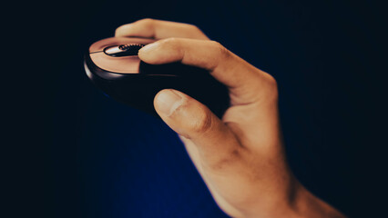 Hand using a modern ergonomic wireless computer mouse, holding and moving in the air, object on side view.