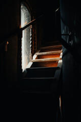 Dark room window of staircase in abandoned house interior sunlight