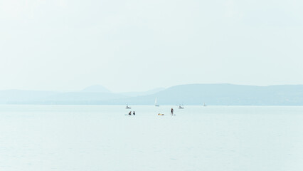 Some sailboats and SUP boards at the lake Balaton on a summer afternoon.