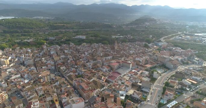 Volando a gran altura nublado sobre pueblo con campanario cristiano 