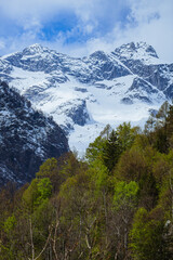 Fototapeta premium the mountains of val masino and val di mello with fresh snow, during a sunny day, near the town of San Martino, Italy - April 2022.