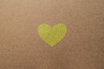 Golden paper heart in the center of craft background
