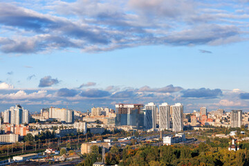 Fototapeta na wymiar A beautiful urban landscape of Kyiv in the rays of the setting autumn sun against the background of a relief cloudy sky.