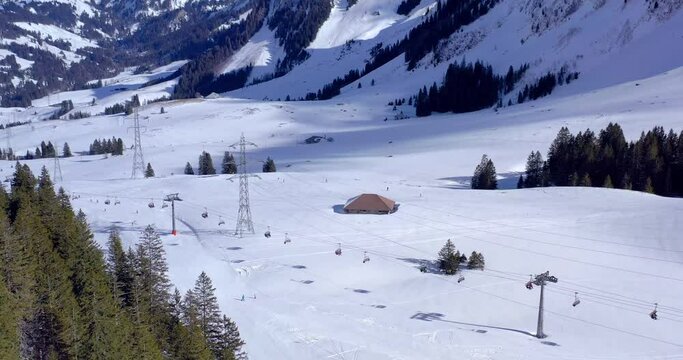 Aerial Shot under the Brienzer Rothorn in S&ouml;renberg Ski Resort with Snow in Winter - Top Destination for Families in UNESCO Biosphere Entlebuch | Switzerland by drone