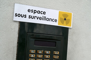 Panneau indiquant espace sous surveillance au-dessus d'un clavier numérique