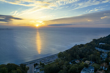 The sun rises over Gdansk Bay in Gdynia from the side of the city boulevard, aerial photo