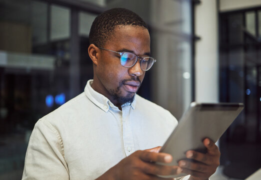 Tablet Research, Night Planning And Businessman Working On Email On The Internet While In A Dark Office At Work. Corporate African Employee Reading Communication Online On Tech While Doing Overtime