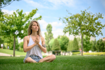 Naklejka na ściany i meble Girl practice yoga meditation outdoor in park