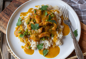 Chicken curry with pumkin, green peas and brown rice on a plate - obrazy, fototapety, plakaty