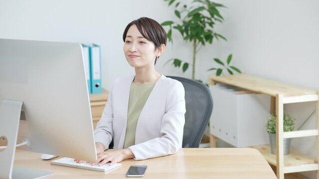 60p　伸びをするオフィスで働く女性（ビジネス・ビジネスウーマン・OL・仕事・パソコン）