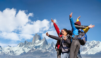 Group of hikers taking selfie on snowy mountains - Happy friends with hands up having fun together...