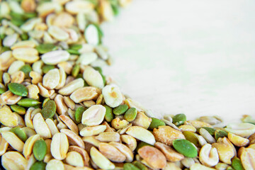 Top view of a mixture of various nuts: sunflower seeds, pumpkin and peanuts. Vegan. Healthy vegetable fats. The concept of healthy nutrition and fitness diet. Selective focus and blurred background