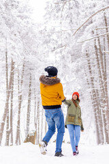 Fototapeta na wymiar Couple having fun in the snow while on winter vacation