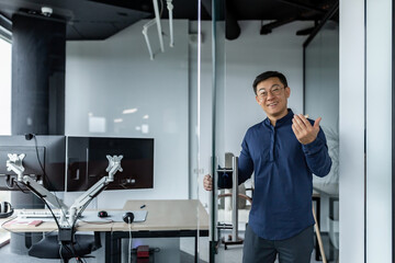 A successful engineer programmer boss invites to his office, an Asian man in a shirt and glasses...