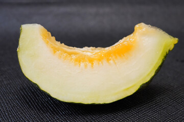 Fresh slices, Traditional Ankara, Kazan, Plain Black Melon on textured black background, 