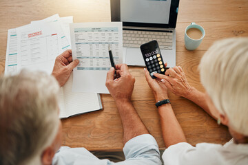 Home budget, finance planning and senior couple calculating their expenses, bills or income during retirement with a calculator, laptop and paper documents from behind. Man and woman discuss savings - Powered by Adobe