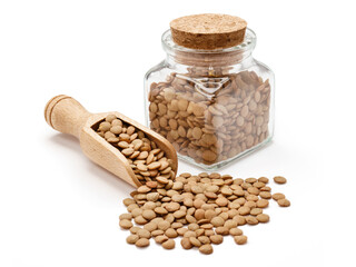 Soczewica w drewnianej szpatułce i małym słoiczku na białym tle