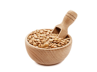 Soczewica w drewnianej misce z łopatką na białym tle
