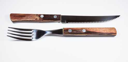 Close up and side view of fork and knife with wooden handle.