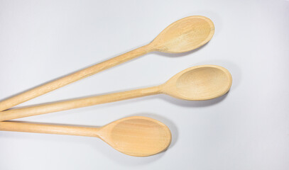 Close up and top view of wooden spoons on white background.