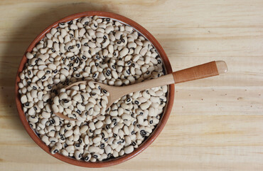 Uncooked Black Eyed Peas in Bowl on Wooden Table