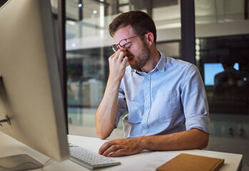 Night business, stress and tired man sitting at his computer desk with headache, depression and...