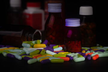 Pills and pill bottles without labels on black background.