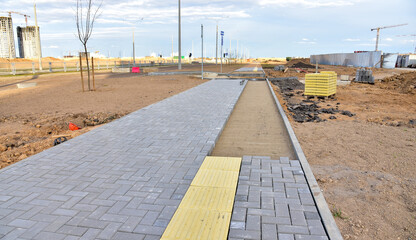 Paving bricks at construction site. Laying paving slabs and borders in town pedestrian zone. Install concrete blocks. Road works on pavement renovation. Block Paving. Brick Pavers for pedestrians.