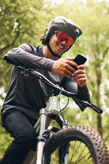 Mountain bike man in nature, phone gps and map direction for adventure, fitness and bicycle break...