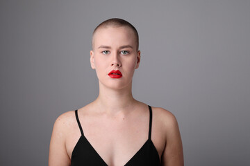 Young bald woman with serious face expression posing indoor. Mock-up.