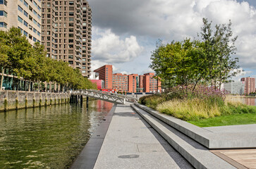 Fototapeta na wymiar Rotterdam, The Netherlands, September 29, 2022: steel, stone and wood pavament and a bed with flower and bushes on the first section of the floating park in Rijnhaven harbour