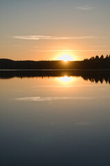 Fototapeta na wymiar Sunset with reflection on a Swedish lake in Smalland. Romantic evening mood