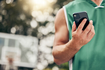 Man, hands and phone in sports communication and social media for basketball in the nature outdoors. Muscular male in sport fitness, exercise and game time check, message or text on mobile smartphone