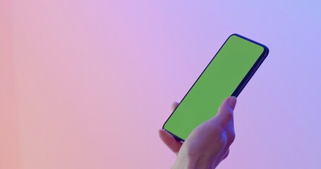 GREEN SCREEN CHROMA KEY CU Caucasian female holding modern smartphone, vertical orientation, colorful neon background